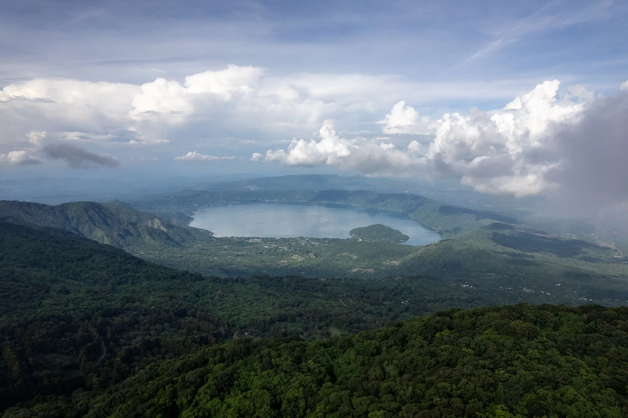 Lake Coatepeque in its volcanic caldera, surrounded by forested hills.